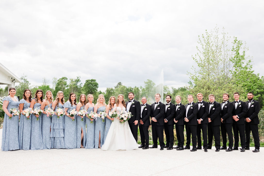 Spring wedding inspiration with bridesmaids in light blue dresses, groomsmen in tuxedos, and pastel floral details.