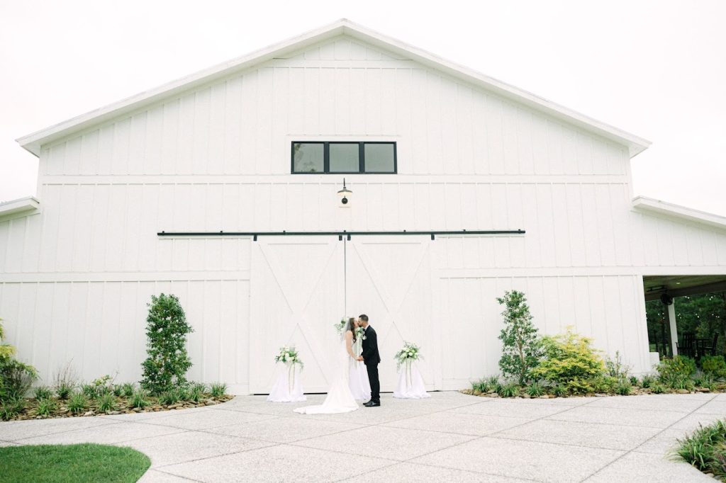 Outdoor wedding ceremony with green and gold décor, floral arch, and organic elements at The Venue at White Oaks Farm.