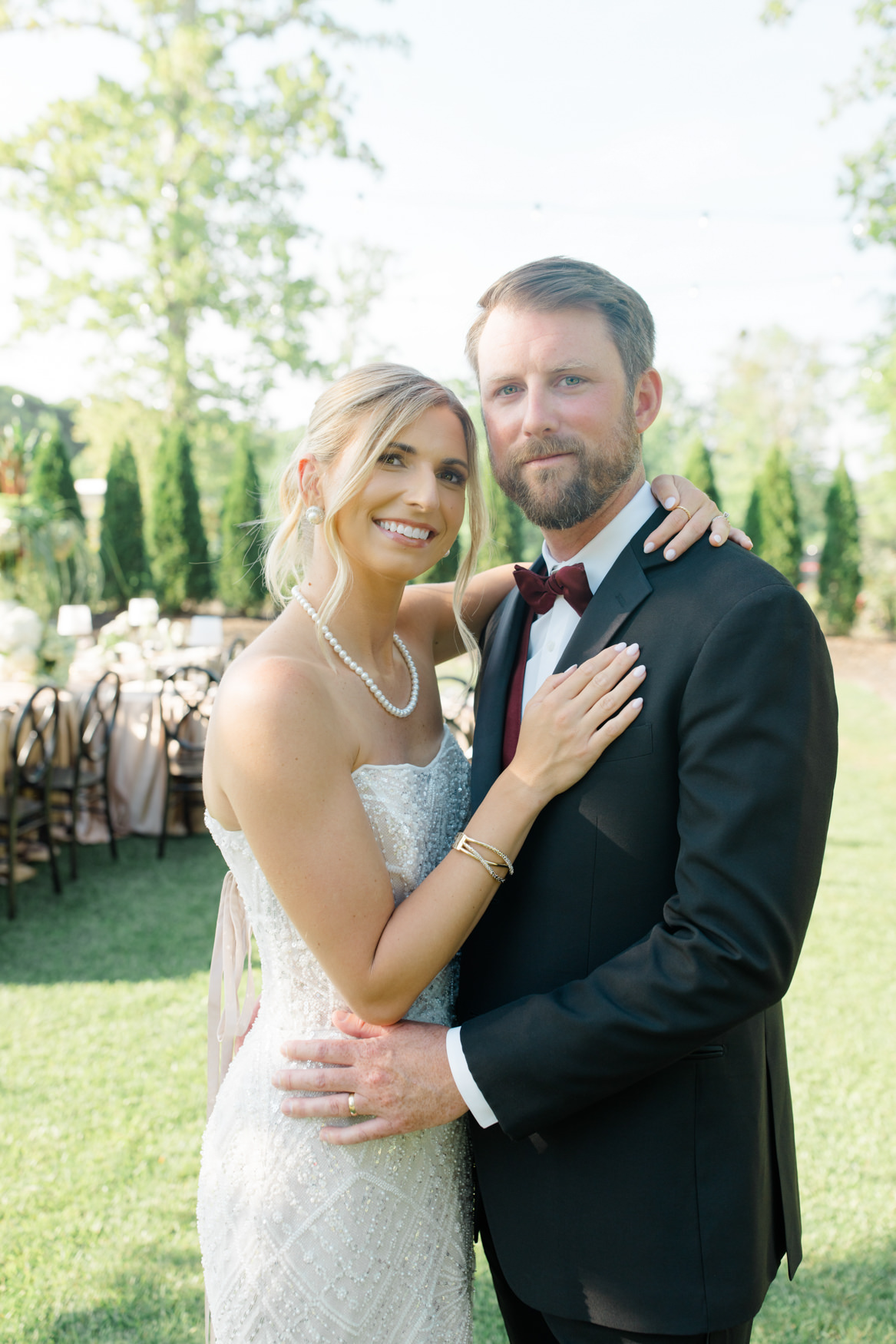 Groom in a black suit and bow tie with his bride in a gown, an example of black tie wedding attire at White Oaks Farm near Myrtle Beach SC